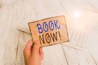 Kavramsal el yazısı şimdi kitabı gösteriyor. İş fotoğrafı metni yer alacağı garanti, çünkü çoktan satın almışsınız. Elinde renkli hatırlatıcı kare şeklindeki kağıt ahşap zemin tutan adam..