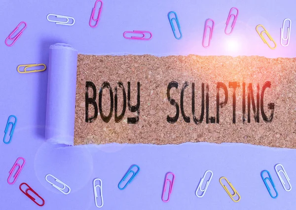 Word writing text Body Sculpting. Business concept for activity of increasing the body s is visible muscle tone Paper clip and torn cardboard placed above a wooden classic table backdrop.