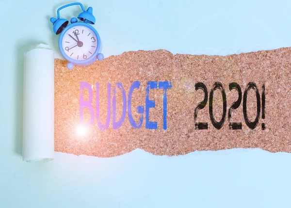 Word writing text budget 2020. Geschäftskonzept zur Schätzung der Einnahmen und Ausgaben für das nächste oder aktuelle Jahr Wecker und zerrissene Pappe über einer klassischen Tischkulisse aus Holz platziert. — Stockfoto