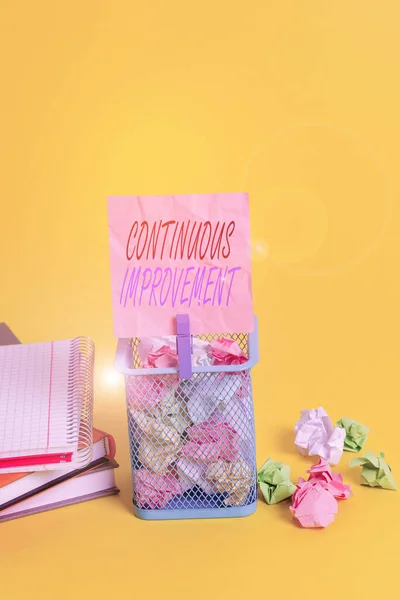 Text sign showing Continuous Improvement. Conceptual photo ongoing effort to improve products or processes Trash bin crumpled paper clothespin empty reminder office supplies yellow.