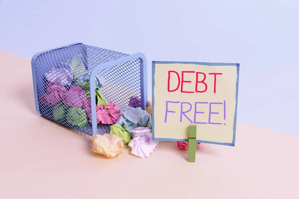 Conceptual hand writing showing Debt Free. Business photo showcasing does not owning any money or things to any individual or companies Trash bin crumpled paper clothespin reminder office supplies.
