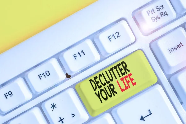 Conceptual hand writing showing Declutter Your Life. Business photo text To eliminate extraneous things or information in life White pc keyboard with note paper above the white background. — Stock Photo, Image