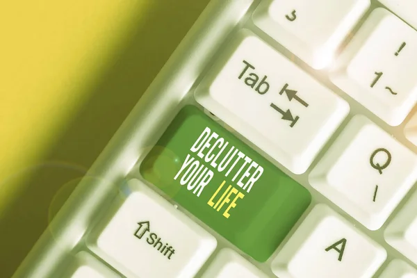 Text sign showing Declutter Your Life. Conceptual photo To eliminate extraneous things or information in life White pc keyboard with empty note paper above white background key copy space. — Stock Photo, Image