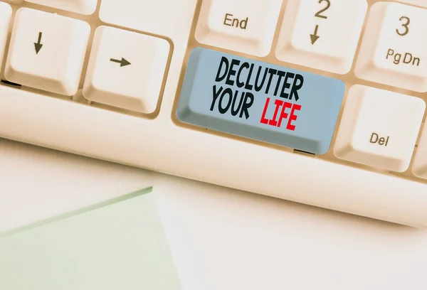 Writing note showing Declutter Your Life. Business photo showcasing To eliminate extraneous things or information in life White pc keyboard with note paper above the white background. — Stock Photo, Image