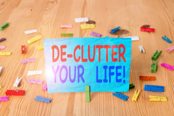 Написання тексту De Clutter Your Life. Концепція бізнесу для видалення непотрібних предметів з непотрібних або переповнених місць Кольорові папери одягу порожні нагадування про дерев'яну підлогу офіс фону . — стокове фото