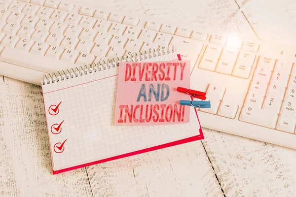 Writing note showing Diversity And Inclusion. Business photo showcasing range huanalysis difference includes race ethnicity gender notebook reminder clothespin with pinned sheet light wooden.