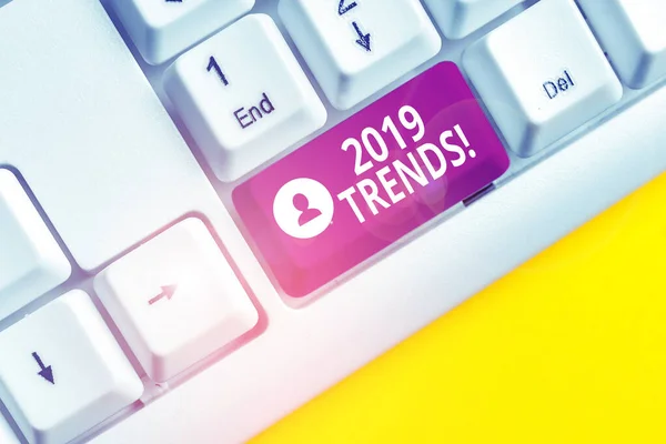 Nota de escritura que muestra las tendencias de 2019. Foto de negocios que muestra la dirección general en la que algo se está desarrollando o cambiando Teclado de PC blanco con papel de nota sobre el fondo blanco . — Foto de Stock