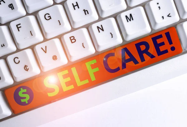 Conceptual hand writing showing Self Care. Business photo text practice of taking action preserve or improve ones own health White pc keyboard with note paper above the white background. — Stock Photo, Image