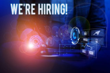 İşe Aldığımızı gösteren bir metin işareti. Başvuruların gözden geçirilmesi ve adayları bulmanın kavramsal fotoğraf süreci Kadın akıllı cihaz kullanarak sunum sunan resmi iş elbisesi giyiyor.