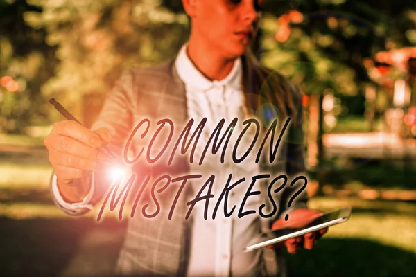 Text sign showing Common Mistakes Question. Conceptual photo repeat act or judgement misguided making something wrong Outdoor background with business woman holding lap top and pen.