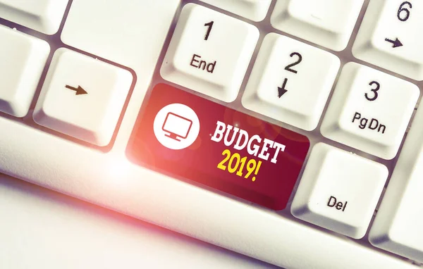 Handgeschreven tekst schrijven budget 2019. Concept betekent de raming van inkomsten en uitgaven voor het huidige jaar wit PC-toetsenbord met lege noot papier boven witte achtergrond sleutel kopiëren ruimte. — Stockfoto