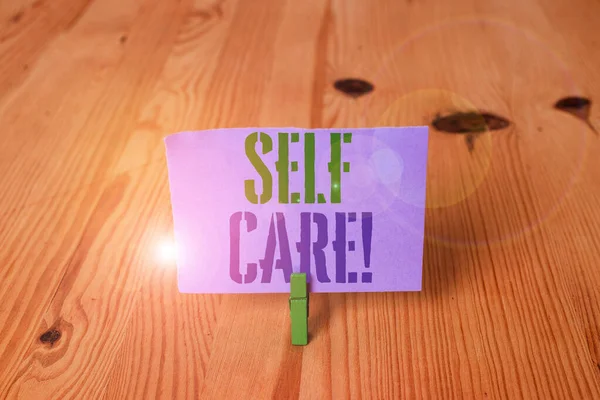 Writing note showing Self Care. Business photo showcasing practice of taking action preserve or improve ones own health Wooden floor background green clothespin groove slot office. — Stock Photo, Image