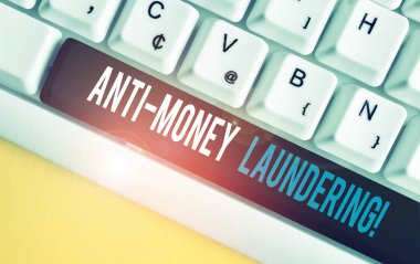 El yazısı metin Anti Money Underundering. Kavram anlamı düzenlemeler yasadışı eylemler le gelir elde etmeyi durdurmak Beyaz pc klavye beyaz arka plan anahtar kopyalama alanı üzerinde boş not kağıdı ile.