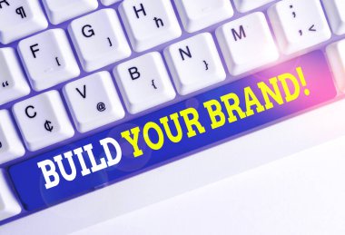 Markanızı İnşa Etmek'i gösteren kavramsal el yazısı. İş fotoğrafı metni oluşturur veya beyaz arka plan üzerinde not kağıdı ile ürün Beyaz pc klavye müşteri bilgi ve görüşlerini geliştirir.