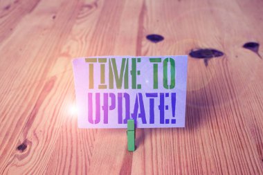 Güncelleştirme Zamanı'nı gösteren not yazma. İş fotoğraf vitrin hareket bir şey birini güncelleme veya güncelleştirilmiş sürüm programı Ahşap zemin arka plan yeşil clothespin oluk yuvası ofis.