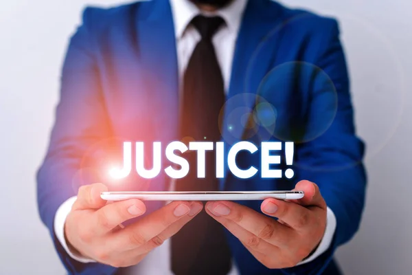 Handwriting text writing Justice. Concept meaning impartial adjustment of conflicting claims or assignments Businessman in blue suite with a tie holds lap top in hands. — Stock Photo, Image