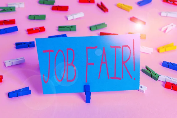 Writing note showing Job Fair. Business photo showcasing event in which employers recruiters give information to employees Colored clothespin papers empty reminder pink floor office pin.