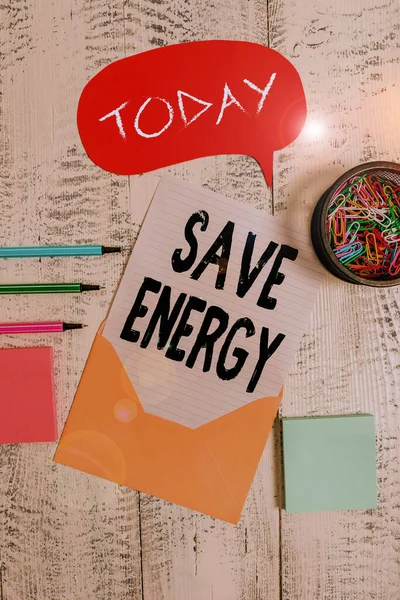 Word writing text Save Energy. Business concept for decreasing the amount of power used achieving a similar outcome Envelop speech bubble paper sheet ballpoints notepads clips wooden back.
