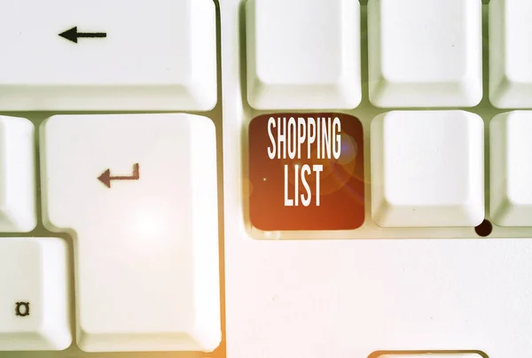 Writing note showing Shopping List. Business photo showcasing Discipline approach to shopping Basic Items to Buy White pc keyboard with note paper above the white background.