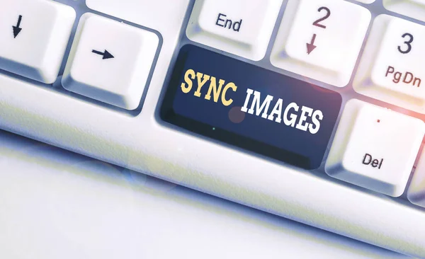 Conceptual hand writing showing Sync Images. Business photo showcasing Making photos identical in all devices Accessible anywhere White pc keyboard with note paper above the white background.