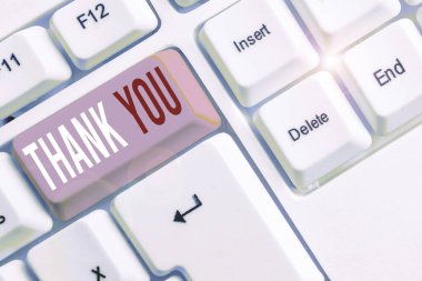 El yazısı metin yazma Thank You. Bir hediye yi veya hizmeti kabul ederken kullanılan kibar bir ifade anlamına gelen kavram Beyaz arka plan tuşu kopyalama alanının üzerinde boş not kağıdı ile beyaz pc klavyesi.