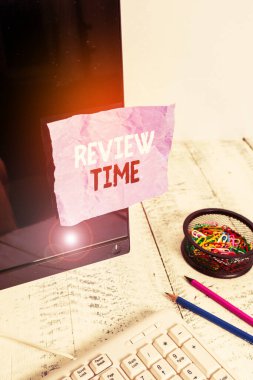 Kelime yazma metni İnceleme Süresi. Bir şeyi yeniden düşünmek veya konuşmak için iş konsepti Klavyenin ve sabitliğin yanındaki siyah bilgisayar ekranına bantlanmış Not kağıdını gözden geçirmek için zamanlamayı ayarlayın.