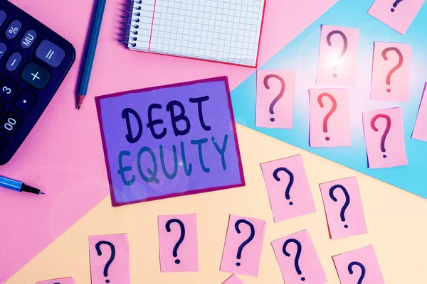 Handwriting text Debt Equity. Concept meaning dividing companys total liabilities by its stockholders Mathematics stuff and writing equipment above pastel colours background.