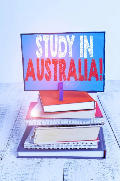 Pisanie notatki pokazujące Study in Australia. Business Photo gablota wchodząc w obcym kraju zamówienia wypełnić swoje badania stos ułożone książek Notatnik kolor PIN przypomnienie. — Zdjęcie stockowe