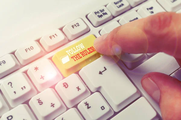 Signo de texto que muestra Seguir las reglas. Foto conceptual ir con las regulaciones que rigen la conducta o el procedimiento Teclado de PC blanco con papel de nota vacío sobre el espacio de copia clave de fondo blanco . —  Fotos de Stock