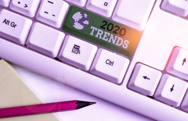 Writing note showing 2020 Trends. Business photo showcasing things that is famous for short period of time in current year White pc keyboard with note paper above the white background.