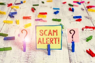 El yazısı metin Scam Uyarısı. Kavram hileli onu karalanmış ve ahşap masaya yerleştirilen ataş ile parçalanan levha ikna ederek kurbandan para elde.