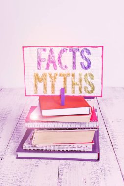 Kelime yazma metin Gerçekler Mitler. Gerçek hayat farkı kazık yığılmış kitaplar defter pin clothespin renkli hatırlatma beyaz ahşap yerine hayal gücüne dayalı iş konsepti.