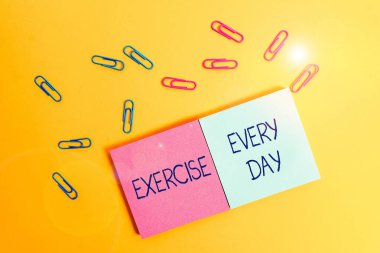 Her Gün Egzersiz gösteren not yazma. İş fotoğraf vitrin eve ve sağlıklı Renkli kare boş yapışkan not defterleri yaprak lar renk arka plan almak için enerjik vücut hareket.