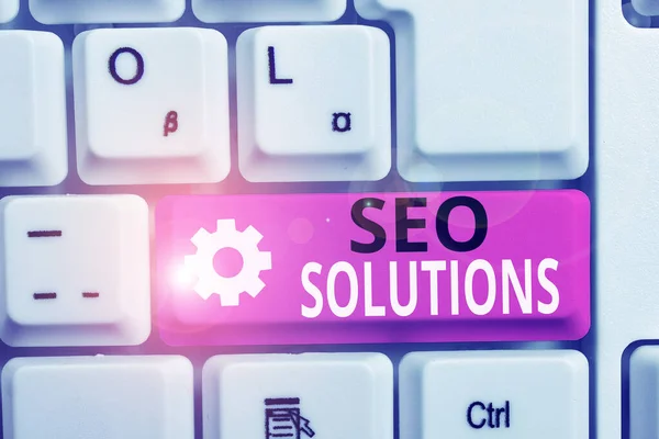 Seo Solutions'ı gösteren not yazma. İş fotoğraf Vitrin Arama Motoru Sonuç Sayfası Sıralaması Beyaz pc klavye beyaz arka plan üzerinde not kağıdı ile Ziyaretçi artırın. — Stok fotoğraf