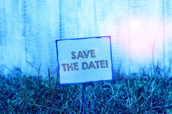 Handwriting text Save The Date. Concept meaning remember not schedule anything else on this day Plain empty paper attached to a stick and placed in the green grassy land. — Stock Photo, Image