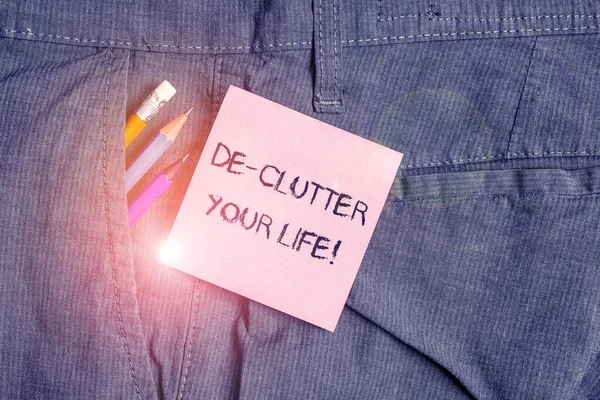 Tulisan tangan konseptual menunjukkan De Clutter Hidupmu. Teks foto bisnis menghapus barang-barang yang tidak perlu dari tempat yang tidak rapi atau penuh sesak Peralatan tulis dan kertas catatan merah muda di dalam saku celana . — Stok Foto
