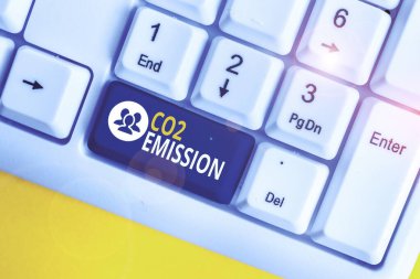 Kelime yazma metin Co2 Emisyon. Zaman içinde atmosfere sera gazlarının serbest bırakılması için Iş konsepti Beyaz pc klavye beyaz arka plan anahtar kopyalama alanı üzerinde boş not kağıdı ile.