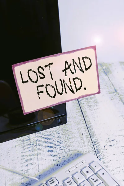 Parola che scrive "Lost And Found". Concetto aziendale per un luogo in cui gli oggetti smarriti vengono memorizzati fino a quando non hanno recuperato la carta per notazione incollata sullo schermo del monitor del computer nero vicino alla tastiera bianca . — Foto Stock