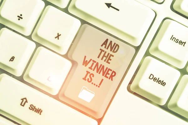 Handstilstext och vinnaren är. Begreppet innebär att tillkännage vem som fick första plats vid tävling eller examen Vit dator tangentbord med tom anteckning papper ovanför vit bakgrund nyckel kopiera utrymme. — Stockfoto