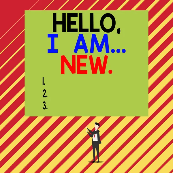 Text sign showing Hello I Am New. Conceptual photo introducing oneself in a group as fresh worker or student Short hair immature young man stand in front of rectangle big blank board.
