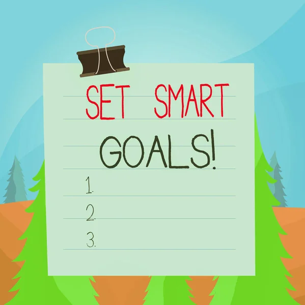 Word writing text Set Smart Goals. Business concept for list to clarify your ideas focus efforts use time wisely Paper lines binder clip cardboard blank square notebook color background.
