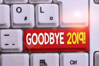 Goodbye 2019'u gösteren bir yazı. İş fotoğraf beyaz arka plan üzerinde not kağıdı ile geçen yıl beyaz pc klavye ayrılırken veya sonunda iyi dileklerini göstermek.