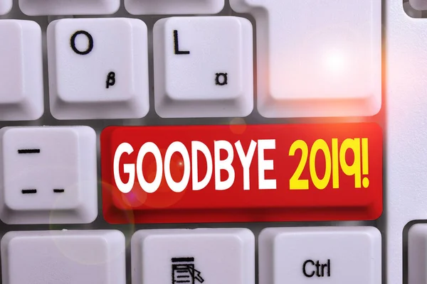 Writing note showing Goodbye 2019. Business photo showcasing express good wishes when parting or at the end of last year White pc keyboard with note paper above the white background.