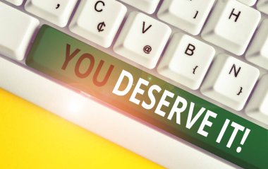 Word yazma metni You Deserve It. İş kavramı için nitelikleri veya eylemleri beyaz arka plan tuş kopyalama alanı üzerinde boş not kağıdı ile Beyaz pc klavye nedeniyle olmalıdır.