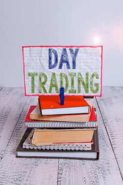 Kelime yazma metin Gün Ticaret. Menkul kıymetler için iş konsepti özellikle satın alma ve finansal enstrümanlar kazık yığılmış kitaplar defter pin clothespin renkli hatırlatma beyaz ahşap.