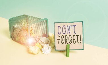 Mesaj işareti Don 't Forget' u gösteriyor. Kavramsal fotoğraf birisine önemli bir gerçeği veya detayı hatırlatmak için kullanılır. Çöp kutusu buruşmuş kağıt çamaşır mandalı boş hatırlatma bürosu malzemeleri..