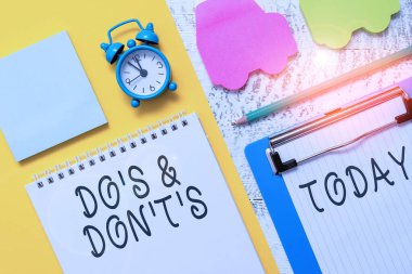 Do S ve Don 't T.S.' i gösteren bir not yazmak iş fotoğraflarındaki karmaşayı akla getiriyor. Not defterindeki levha işaretleyici araba alarm saatini tahta arka plana yapıştırıyor..