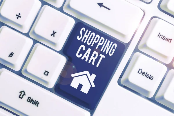 쇼핑 카트를 보여주는 개념적 손 쓰기. 비즈니스 사진 전시 케이스 트롤리 운반 식료품 및 상품 화이트 PC 키보드 흰색 배경 위에 메모 종이. — 스톡 사진