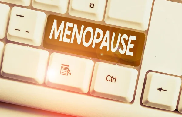 Conceptual hand writing showing Menopause. Business photo text Period of peranalysisent cessation or end of menstruation cycle White pc keyboard with note paper above the white background. — Stock Photo, Image