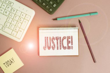 Adaleti gösteren bir not yazıyorum. Çelişkili iddiaların ya da atamaların tarafsız bir şekilde düzeltilmesi, ahşap masaya yerleştirilen donanım ve bilgisayar malzemelerini gösteren iş fotoğrafı.